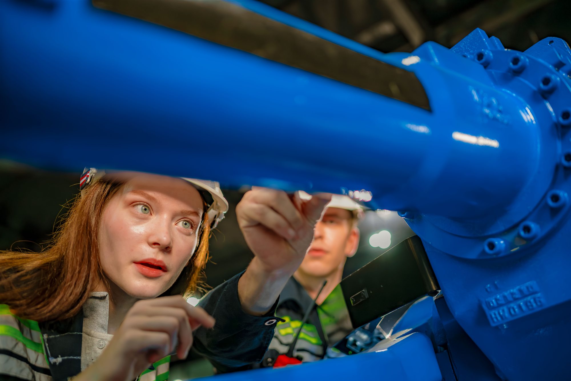 Automation engineers closely inspecting a robotic system component