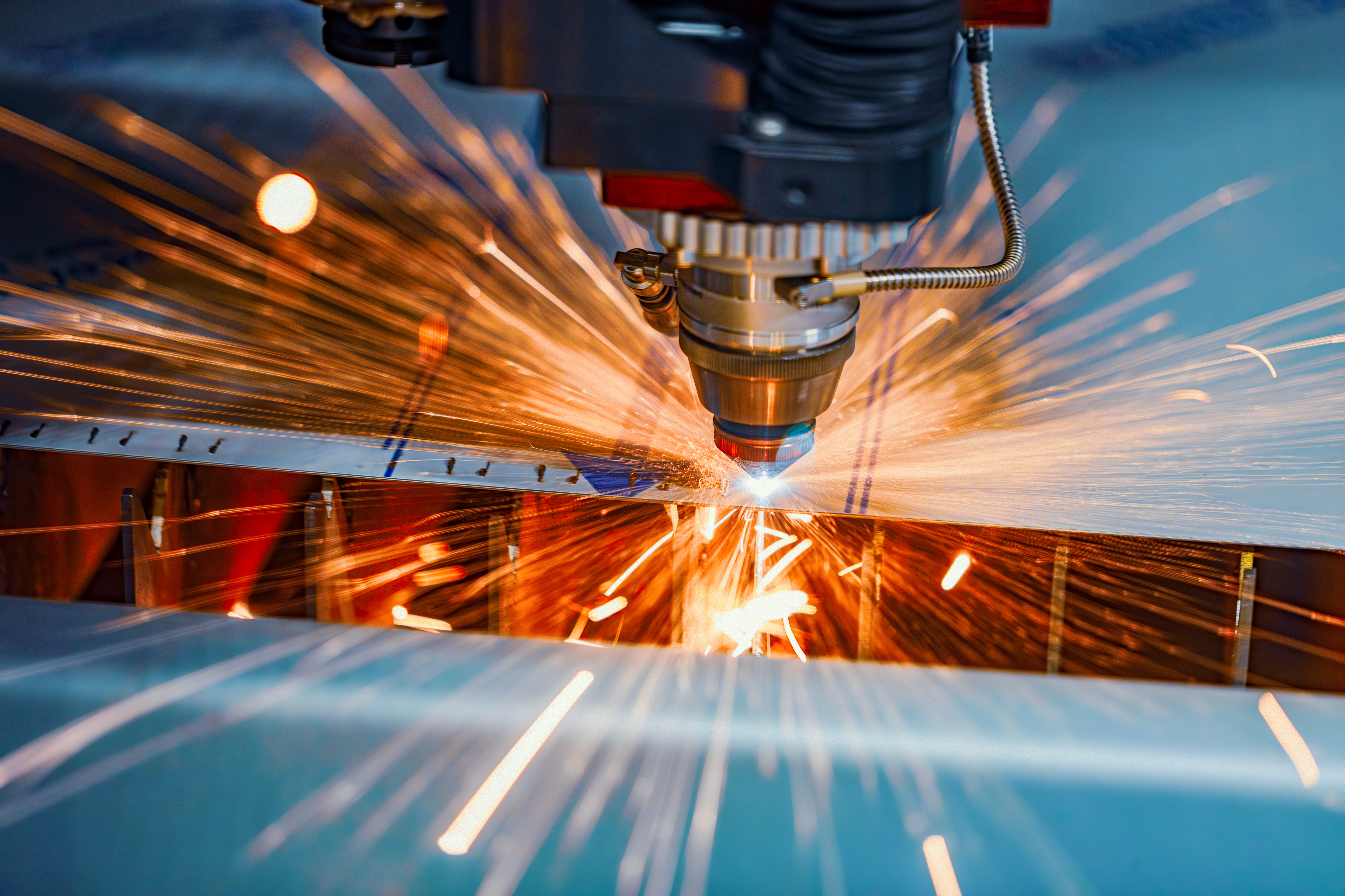 Industrial laser machine cutting sheet metal in a production setting